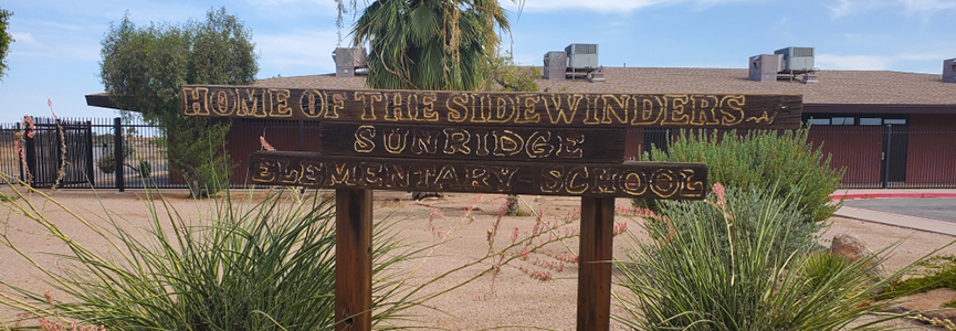 A wooden welcome sign saying Home of the Sidewinders - Sunridge Elementary School
