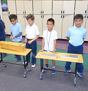 Sunridge students standing with musical instruments in hallway